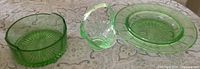 Three uranium glass pieces: butter dish base, basket, plate