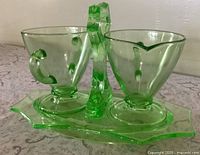 Front view of creamer, sugar bowl and handled caddy tray