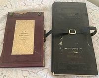 Front view of both vintage books showing covers and strap