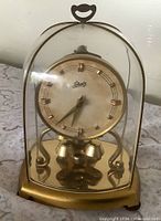 Front view showing dial, dome, base, pendulum
