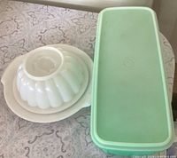 White jello mold and green vegetable container side by side