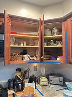 Cabinet and countertop view showing glassware, salt & pepper shakers, Nespresso machine, blender base, toaster