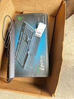 Razer Lycosa keyboard retail box and Dell keyboard cable visible in cardboard box
