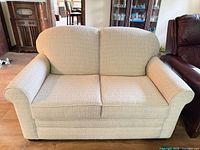 Front view of beige woven EmeraldCraft loveseat