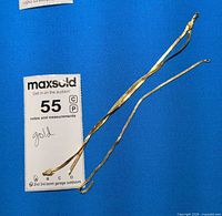 Overview of two gold-tone chain necklaces with lot tag