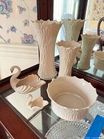 Group shot of all five Lenox ivory porcelain pieces inside cabinet