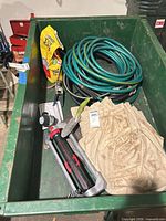 Overall lot showing hoses, sprinkler, tools, drop cloths in bin
