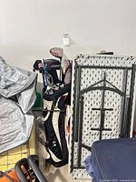 Full view of Ogio stand bag with assorted clubs and folded table nearby