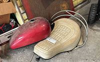 Red metallic gas tank, tan seat and chrome rails on floor