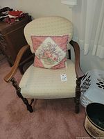 front view of armchair showing upholstery, wood frame, included pillow, size tag visible