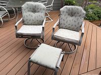 Front view of two swivel chairs and ottoman with cushions on deck