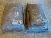 Two sealed bath sheet packages on table