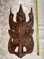 Front view showing full carved bird plaque with ruler for scale