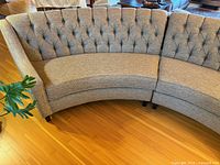 Front view showing curved shape and button-tufted back