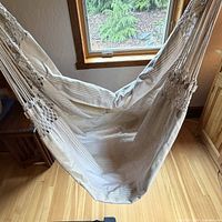 Full view of fabric seat suspended from bar