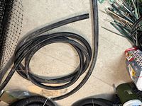 Coiled black flexible pipe with additional straight segment