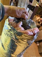 Open end of foil-jacketed insulated duct showing pink fiberglass and black inner core