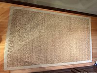 Full view natural fiber rug with fabric border