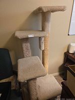 Full view of assembled beige cat tree showing top and middle platforms