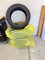 Four tires, three bagged and one standing upright