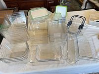Group of assorted clear plastic bins with lids and handles displayed on table