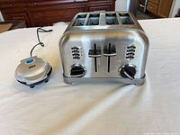 Front view Dash 4-slice toaster with Dash mini waffle maker beside it