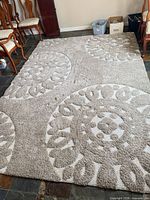 Full view of beige high-pile rug showing medallion pattern