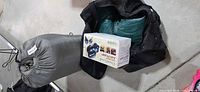 Boxed GreatLand air pump beside duffel bag with folded green mattress and grey rolled bag