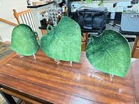Three green leaf platters on stands, full view