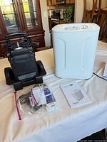 Full lot showing concentrator, carrying case on cradle, battery/charger in bag, manual