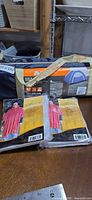Tent carry bag with packaging visible, two rain ponchos in front