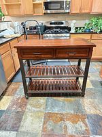 Full view of rolling kitchen island cart showing drawers, shelves, metal frame and casters