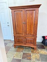 Front view of cherry entertainment armoire