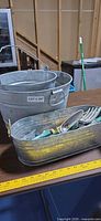 overview showing two galvanized buckets and oval tub with tools