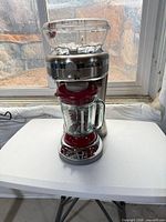 Front view of Margaritaville frozen drink maker showing ice hopper, control panel, and glass pitcher