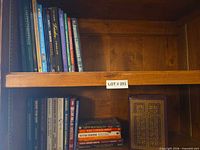 Two shelves showing mixed book spines, upper shelf mostly religion and assorted hardcovers
