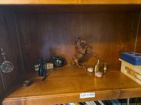 Overview of all items on shelf including hanging prism, flashlight, spoon, glass orb, horse figurine, brass boots, rose quartz hearts, tin and wooden boxes