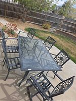Full view of metal patio table with six matching chairs