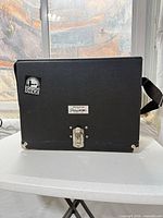 Front view of black Pachmayr case showing latch, logo plate, sticker