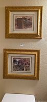 Both framed prints hung on wall