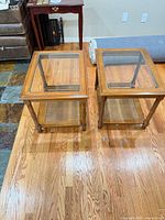 Both oak glass-top end tables side by side showing overall design