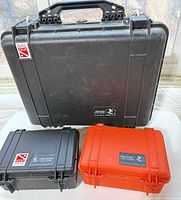 Front view of three Pelican hard cases displaying sizes, colors, external condition