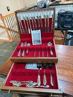 Open flatware chest showing knives in lid, forks, spoons and drawer with serving pieces