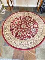 Full view of round red oriental area rug showing overall size and border design