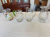 Group shot of all four glass pitchers in lot