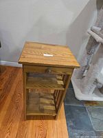 Full view of end table front showing drawer, shelves, and finish