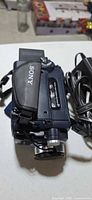 Sony blue Handycam camcorder top and side view with attached battery and power cable