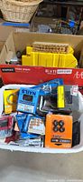 Bin of assorted tools & hardware showing casters, nails, tape, felt pads