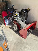 Full view of Toro Power Max 726 OE snow blower showing auger housing, wheels with chains, and general cosmetic state