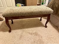 Full view of upholstered bench showing wood frame and cabriole legs